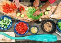 various vegetables being cut on a cutting board