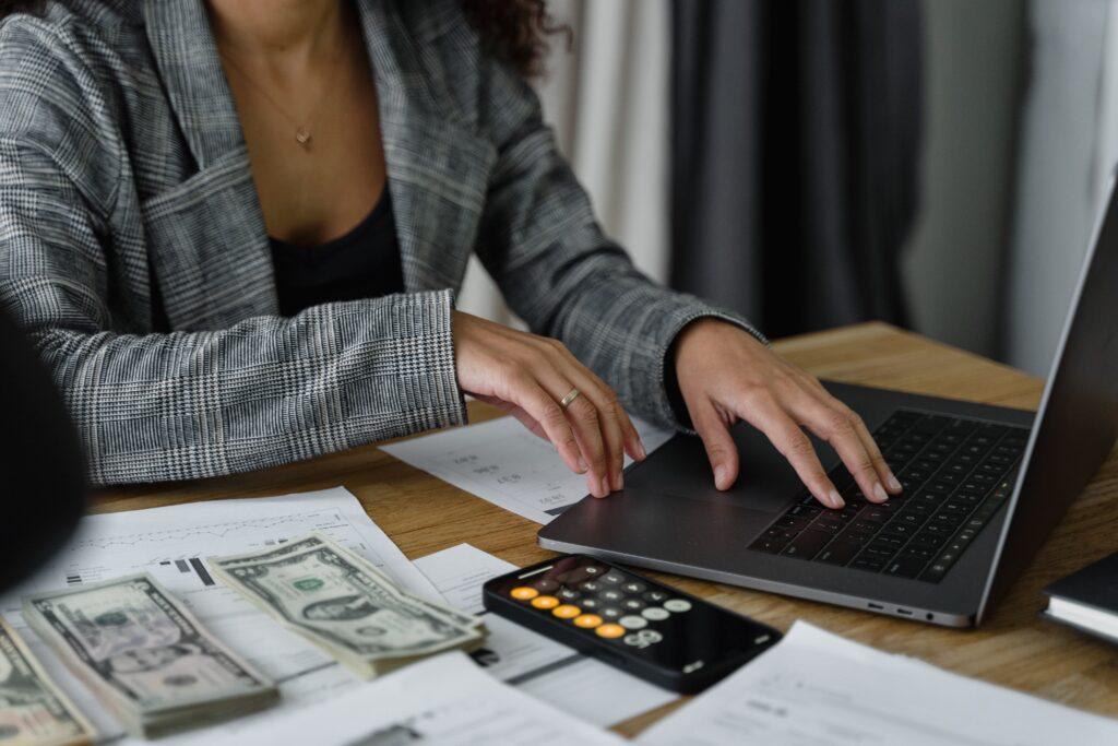 woman figuring out her food budget with a laptop