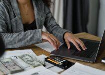 woman figuring out her food budget with a laptop