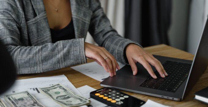 woman figuring out her food budget with a laptop