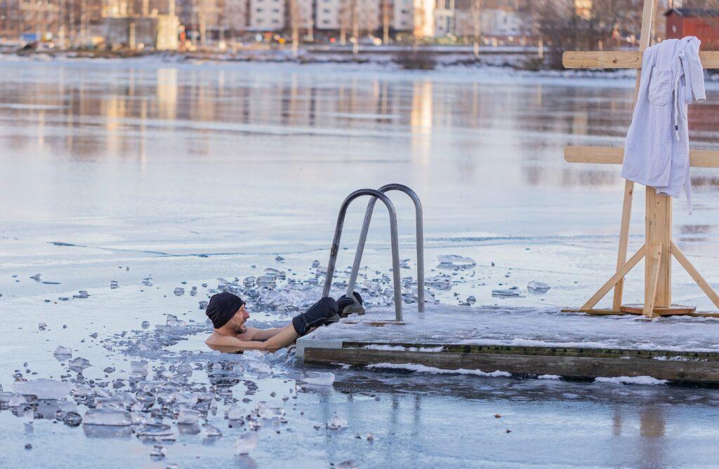 man taking a cold water plunge in a lake