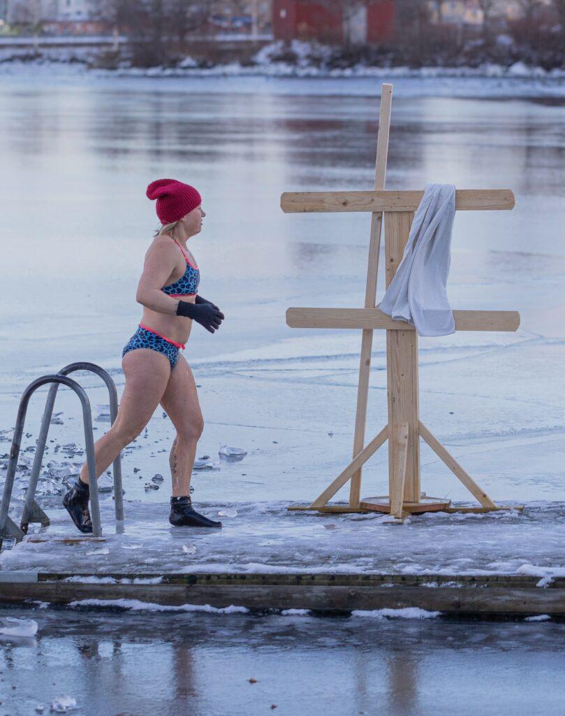woman walking on a dock after taking a cold water plunge